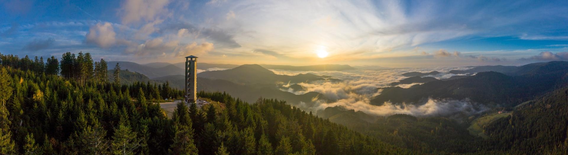 Buchkopfturm Oppenau Blick über die Schwarzwaldberge mit dem Buchkopfturm auf der linken Seite. Im Hintergrund Sonnenschein und Nebelmeer