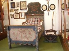 großes Bett aus Holz links im Bild, eine kleine Variante rechts daneben