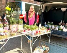 Vergissmeinnicht / Simone Streck-Bartke Ein Verkäufer steht hinter seinem Verkaufstisch mit Blumen