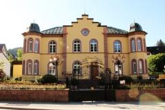 Gelbes Postgebäude mit Erker rechts und links. Sandstein um Fenster und Kanten