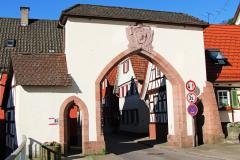 Das Oppenauer Stadttor, auch Schwabentor genannt Stadttor, weiß/beige verputzt mit großem Sandsteinbogen über der Straße und jeweils einem kleinen bei den Gehwegen